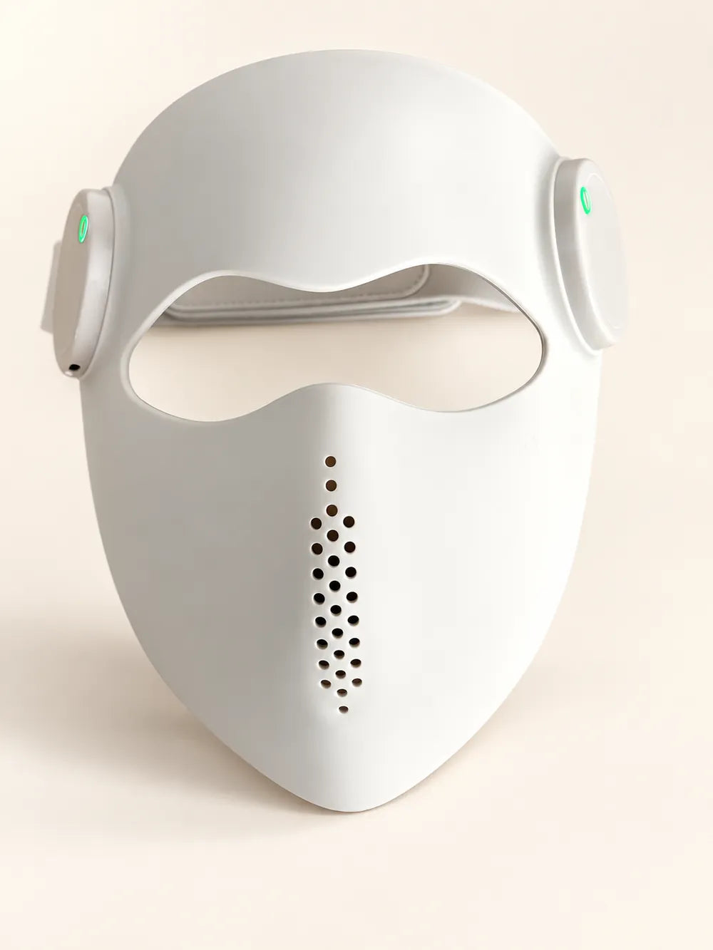 Front view of the cream Luxe Mask with eye opening and central vents on an ivory studio background