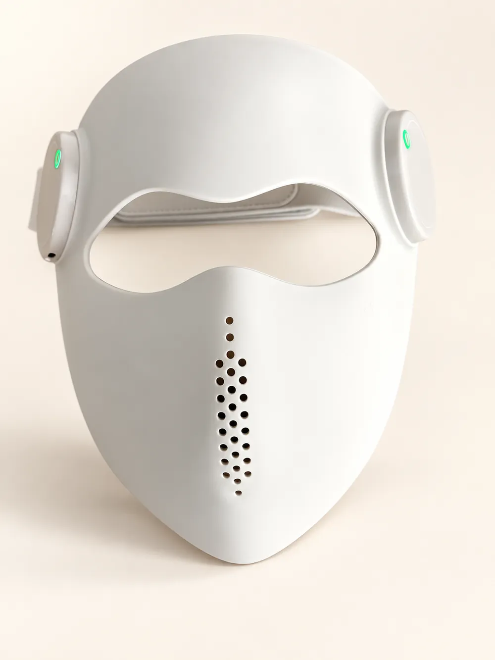 Front view of the cream Luxe Mask with eye opening and central vents on an ivory studio background